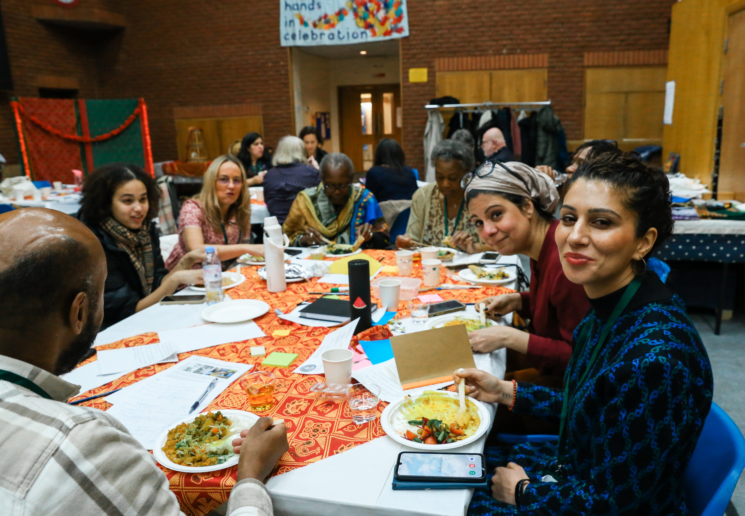 IMG_2668 A table of smiling people at a Harrow Giving event