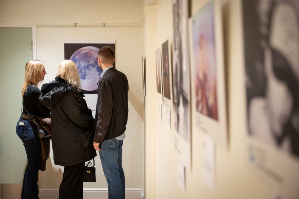 Visitor view winning photographs in the exhibition