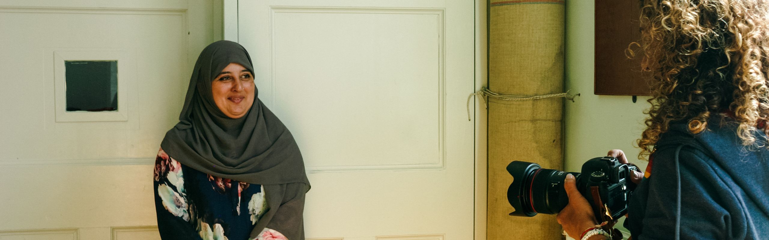 A photographer takes a photo of one of the women contributing to Families in Action Together's project