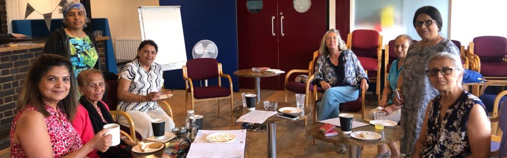 A group have tea at a Harrow Carers event